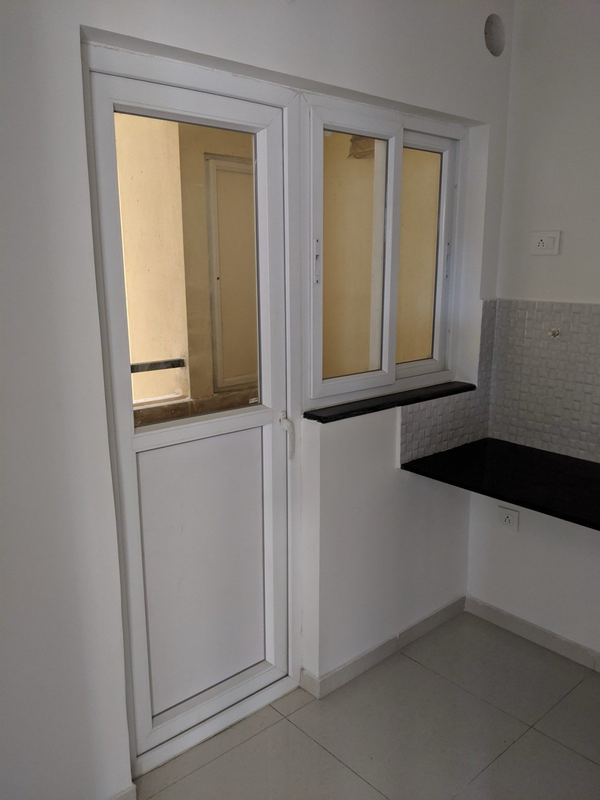 A white uPVC door-cum-window installed in an apartment