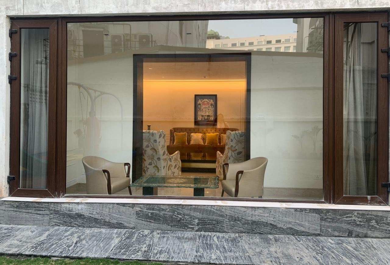 Wood-finish uPVC French doors opening a sitting room onto a granite terrace