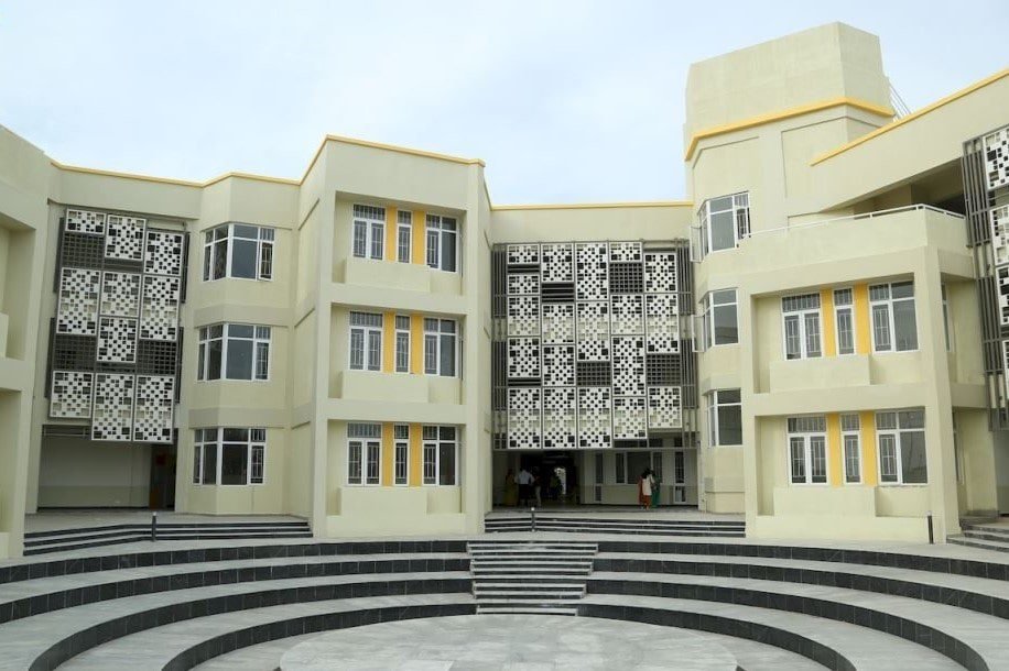 KC High School in Navalur, classroom wings around a stepped amphitheatre