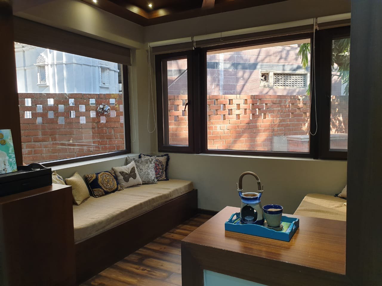 A reading nook framed by walnut-finish uPVC casement windows, Kilpauk
