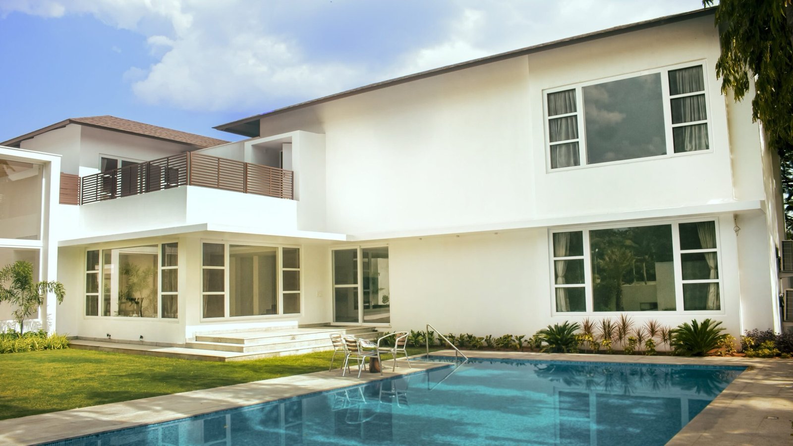 The white Uthandi beach house and its pool, with large uPVC windows on both floors